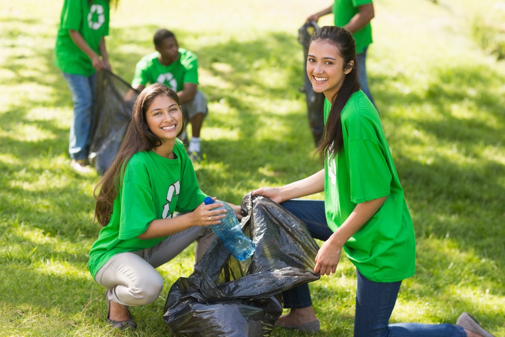 Team of young volunteers picking up litter in the park